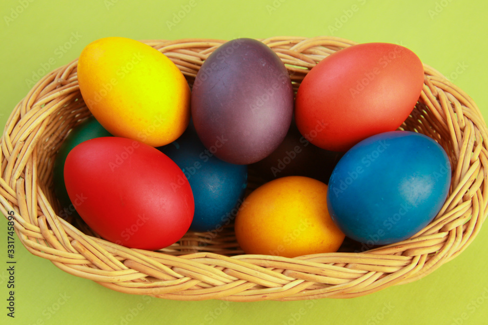 Easter eggs colors in basket green background Easter eggs colors in basket green background
