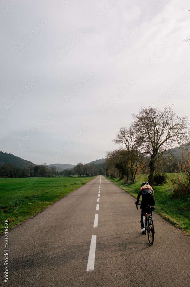 Fototapeta premium Female cyclist rides fast in spain