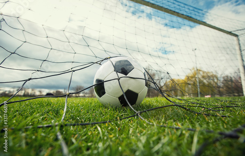 Close up of a soccer ball enters the gate and hits the net, goal concept. Football championship background, spring outdoors tournaments. Healthy sports activity and games. © 1STunningART
