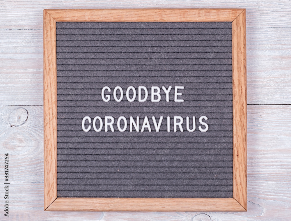 grey felt Board with the English goodbye coronavirus on a wooden background. concept of the risk of spreading coronavirus