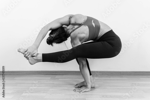 Unsaturated photography of a woman doing a variation of the Utkatasana yoga position