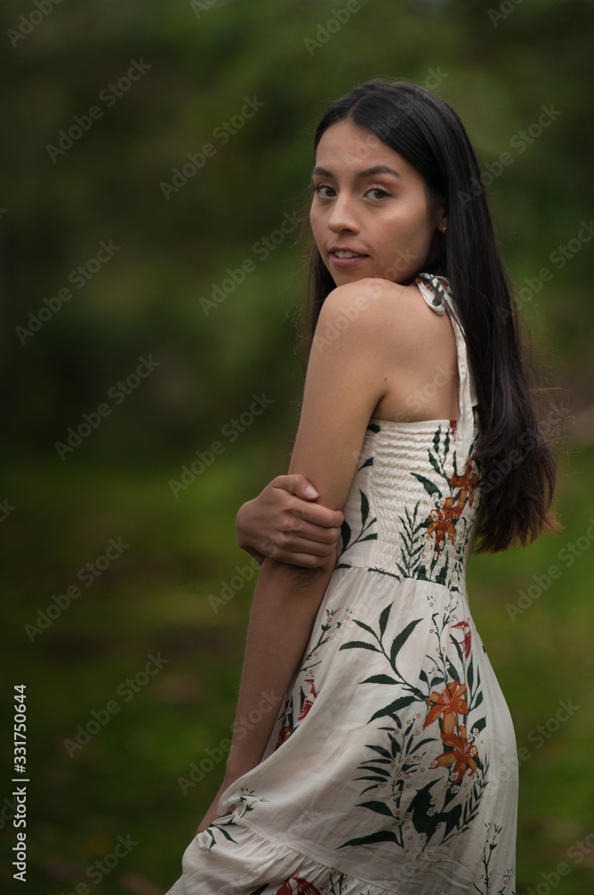 young woman with dress in the middle of nature looking at the camera young woman with dress in the middle of nature looking at the camera