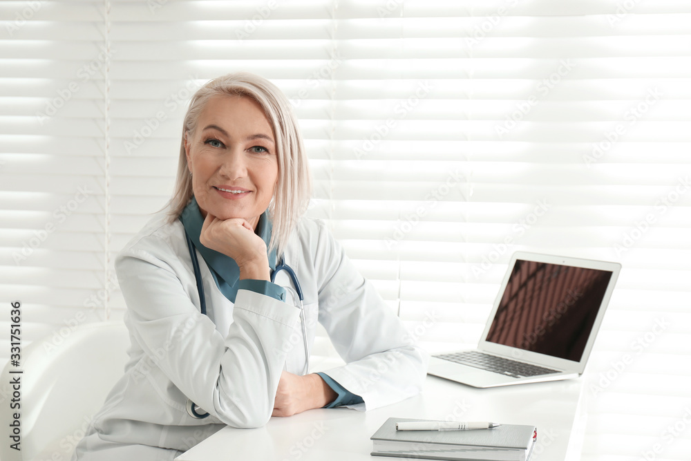 Portrait of mature female doctor in white coat at workplace Portrait of mature female doctor in white coat at workplace
