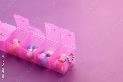 Close up of pink color pills in a pill box 