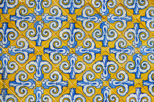 Marble-stone mosaic texture. Ornamented tiles texture background. ancient Spanish, european yellow and blue mosaic, Picturesque Europe city wall.