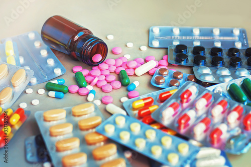 Composition of medicine bottle and pills on gray background, selective focus. 