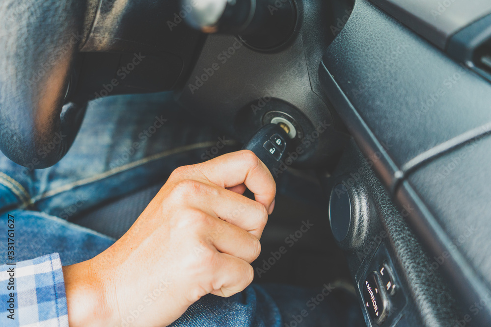 Closeup inside car of hand male holding key in ignition start engine key. Closeup inside car of hand male holding key in ignition start engine key.
