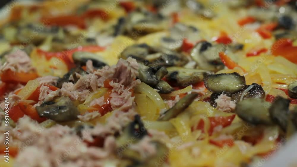 Putting tuna on pizza. Close up and selective focus Putting tuna on pizza. Close up and selective focus