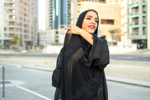 Portrait of beautiful middle eastern arab woman wearing abaya on the street