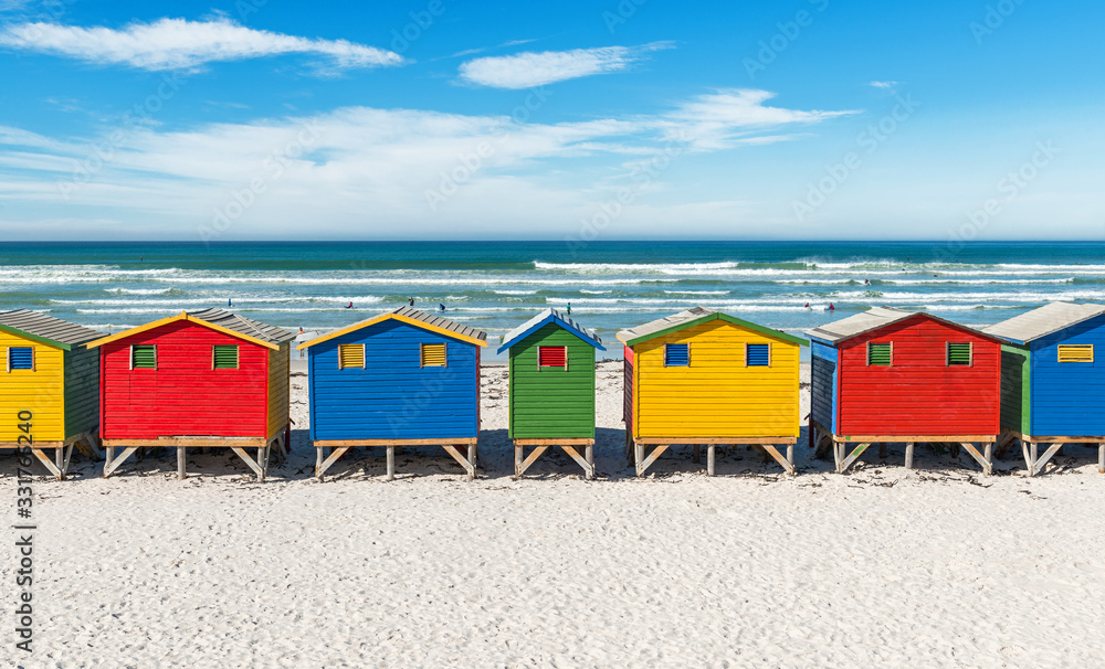 Fototapeta premium The famous beach of Muizenberg with its colorful beach huts, also known as a surfers paradise, near Cape Town, South Africa.
