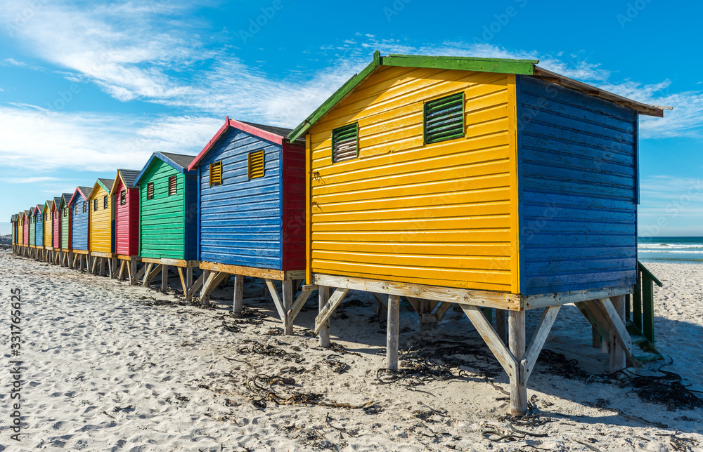 Naklejka premium Colorful wooden beach huts on Muizenberg beach near Cape Town, a famous place for surfing, South Africa.