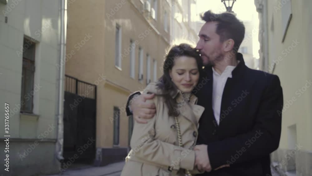 Happy man and woman walk down the street in sunny weather Happy man and woman walk down the street in sunny weather