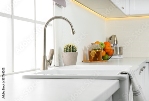 Ceramic sink and modern tap in stylish kitchen interior