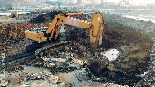 Excavator cleaning quarry. Construction equipment, heavy industry machinery.