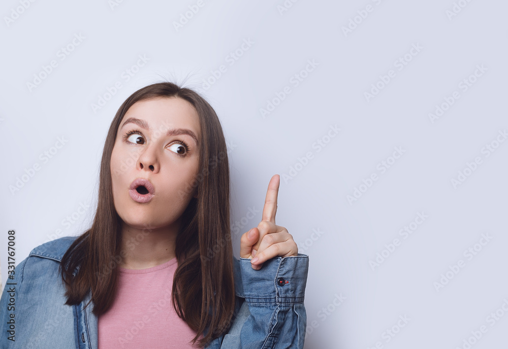 cheerful young lady points a finger at space cheerful young lady points a finger at space