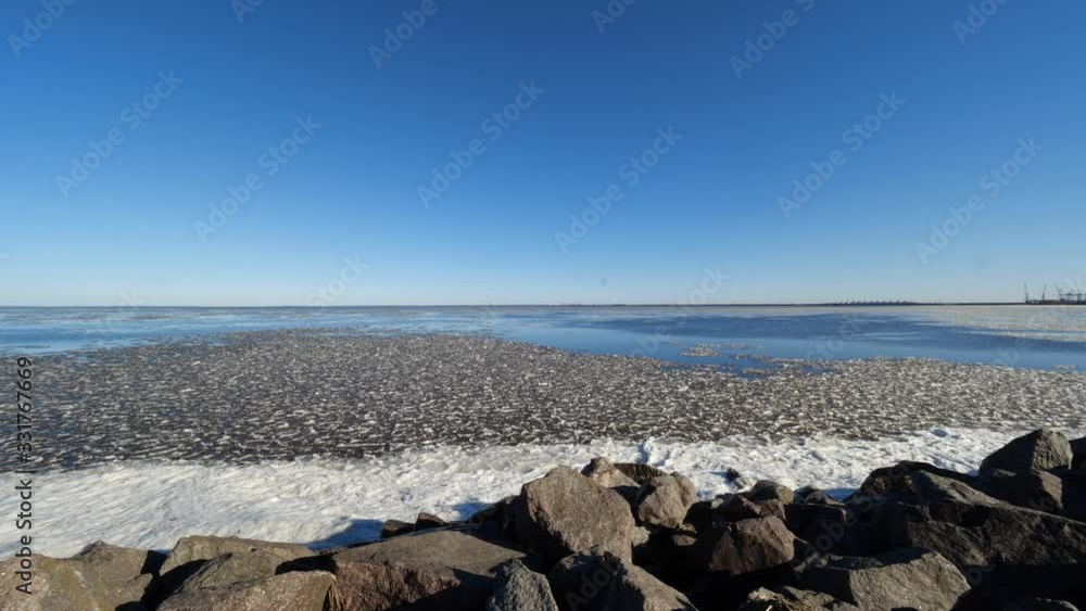 panorama of the bay with pieces of ice and a rocky shore in the rays of bright spring sun panorama of the bay with pieces of ice and a rocky shore in the rays of bright spring sun
