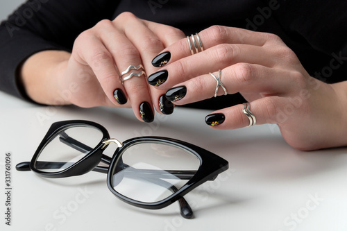 Beautiful womans hand with elegant manicure. Minimal black nail design.