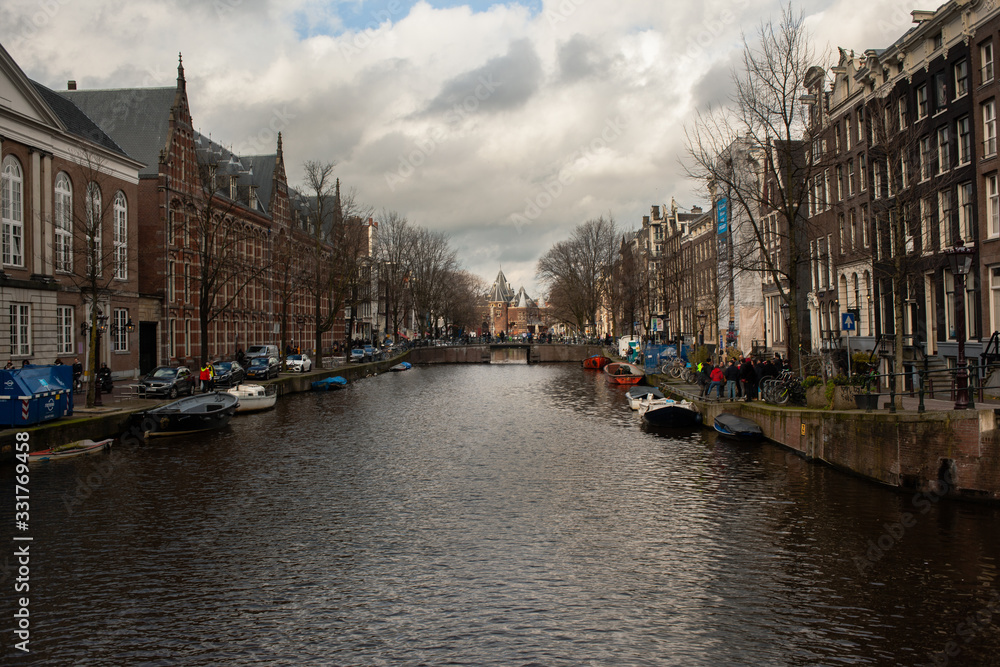 Amsterdam canals with cloudy sky and boats