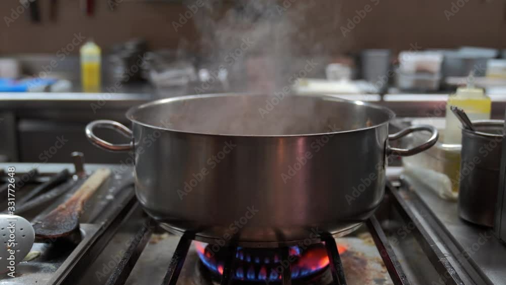 Stainless casserole over a flame on restaurant kitchen. It is hot. Stainless casserole over a flame on restaurant kitchen. It is hot.