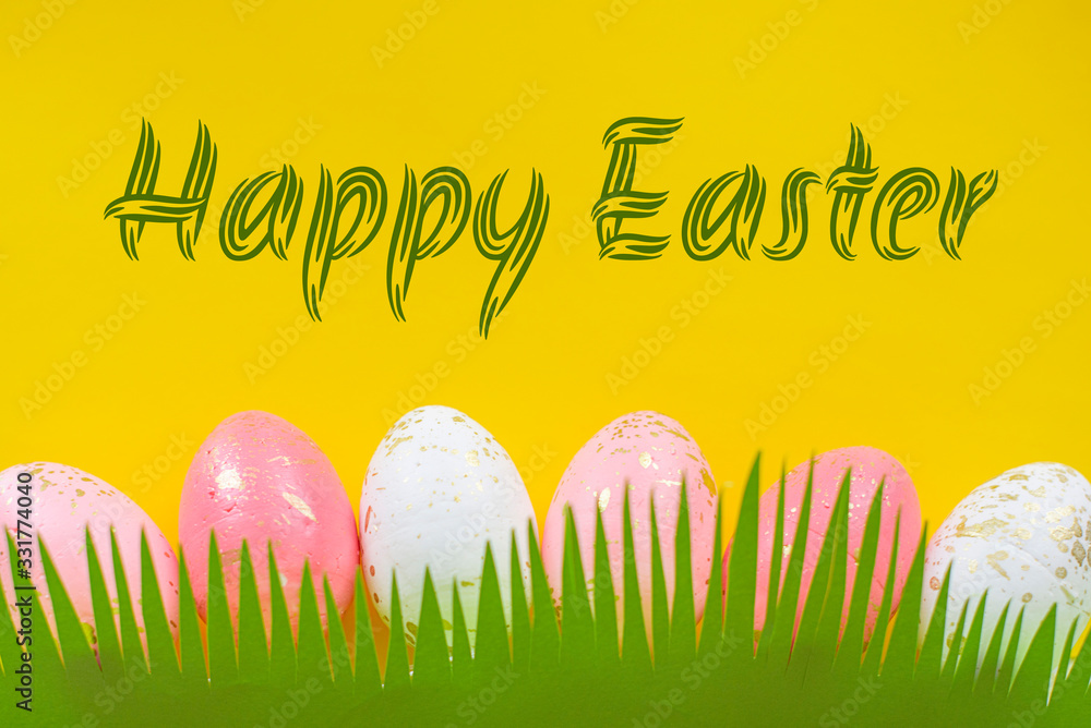 Concept of spring and Happy Easter pink and white with gold eggs on a colorful yellow bright background, grass cut out of paper