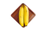 Yellow ripe bananas on a wooden board, isolated from a white background and copyspace
