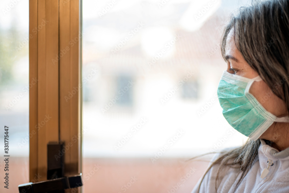 Sick woman of corona virus looking through the window Sick woman of corona virus looking through the window