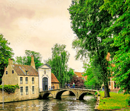 View of a bridge over a small canal leading to an aesthetic house  in Brugge, Belgium photo