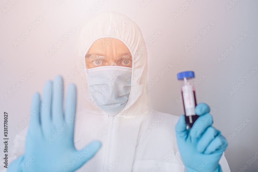Scientist in protective suit holding test tube with blood Scientist in protective suit holding test tube with blood