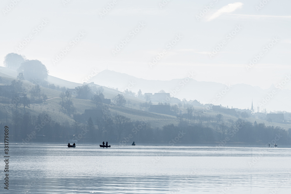 fisherboat in the morning with alps panorama in background monochron and quiet sunrise scenery