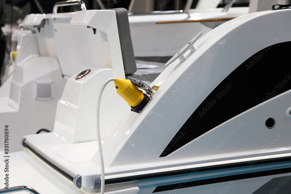 Electric plug of the shore power supply is connected to the outlet on Board the motor yacht, Parking in the Marina