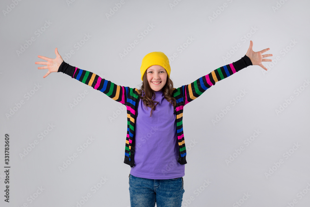 Happy schoolgirl in purple T-shirt and yellow hat on white background Happy schoolgirl in purple T-shirt and yellow hat on white background