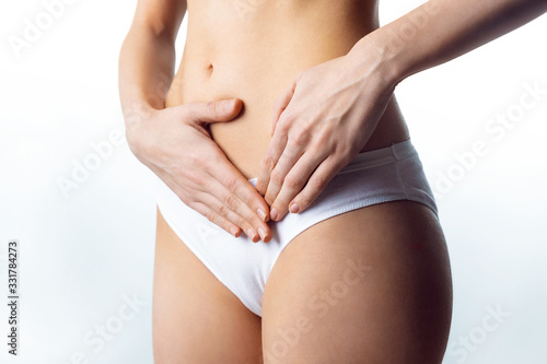 Woman dressed in underwear suffering from menstrual pain. Isolated on white background.