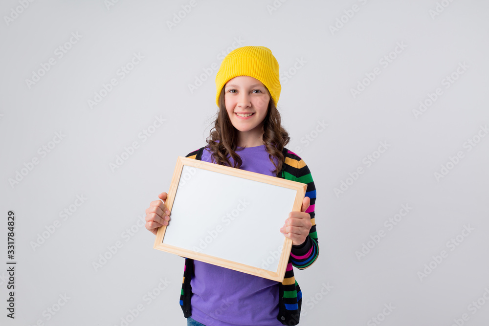 Teenage girl holds an empty drawing board, space for text Teenage girl holds an empty drawing board, space for text