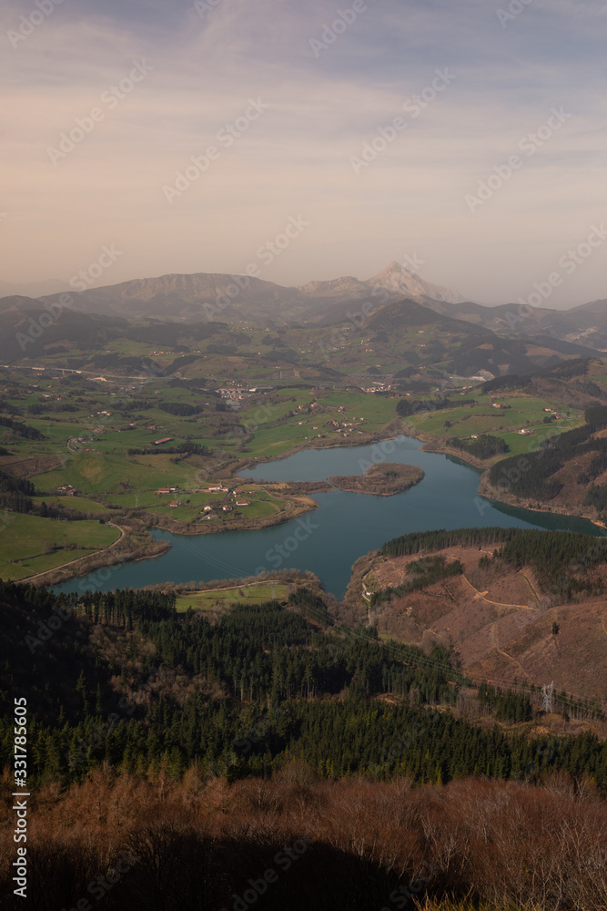 Urkulu reservoir surronded by mountains seen from the top of Orkatzategi hill, in Aretxabaleta, Basque Country.