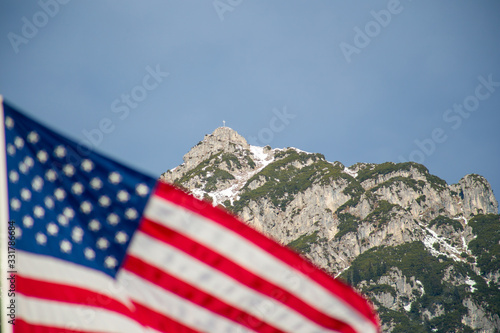 Wawing American flag against mountains of rocks and blue sky