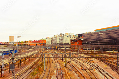 Railway tracks and trains near Stockholm's main train station in Norrmalm area, Stockholm, Sweden in sunset. Silhouette of city hall and cathedral in background. Horisontal composition