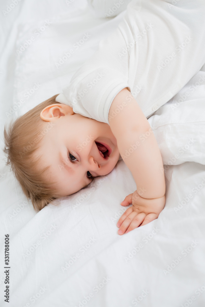Adorable baby boy in white sunny bedroom. Newborn child relaxing in bed. Nursery for young children. Textile and bedding for kids. Family morning at home. New born kid during tummy time with toy bear. Adorable baby boy in white sunny bedroom. Newborn child relaxing in bed. Nursery for young children. Textile and bedding for kids. Family morning at home. New born kid during tummy time with toy bear.