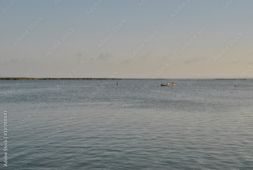 Small boat sailing on the lake in summer