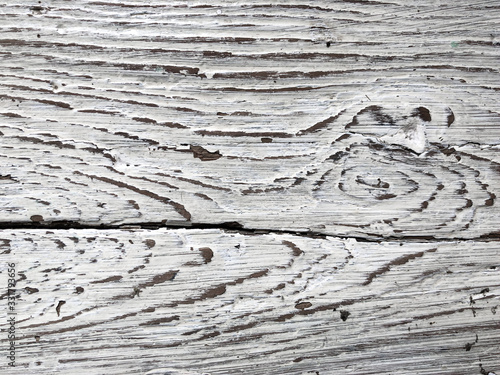 Embossed texture of an old painted wooden board. White board with cracks and scratches. Aged oak surface with a beautiful natural texture. Horizontal fibers of a tree. Vintage background in provence
