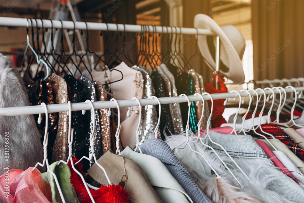 a lot of clothes hangers that are closely located next to each other in a  store with women's clothing, an atmosphere of women's space with a large  selection of colorful clothes Photos