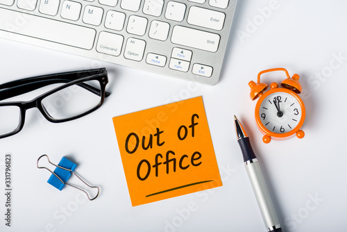 Out of office - memo on office workplace. Holiday Announcement, Day Off or Quarantine Covid-19 photo