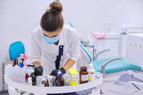 Female dentist doctor working with medical materials and tools