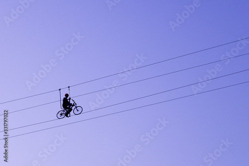 Man balancing on a bicycle on a rope
