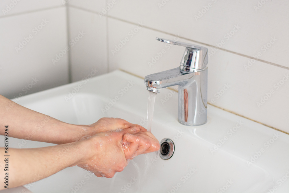 Washing the hands with soap under tap water Washing the hands with soap under tap water