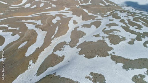 Aerial panorama, highland terrain relief, snowy spots pattern on rocky ground