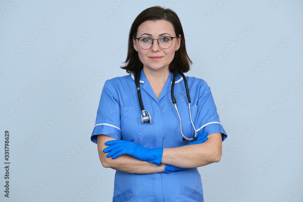 Female medical worker in blue uniform with stethoscope and gloves Female medical worker in blue uniform with stethoscope and gloves