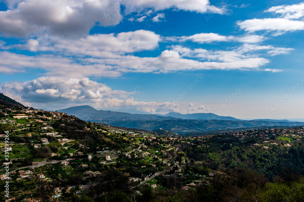 A wide / high angle panoramic view of Saint-Jeannet buildings and other towns covering the low Alps mountains hills with the mountain ranges in the haze (French Côte d'Azur/ Provence/ Riviera)