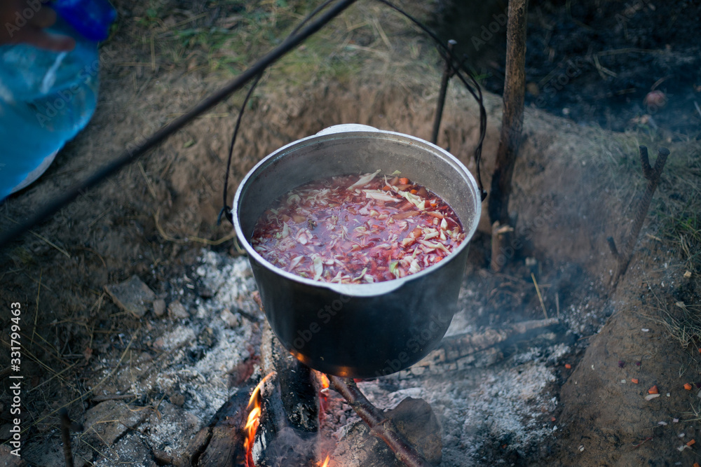 Cauldron with soup on a campfire in a hike Cauldron with soup on a campfire in a hike