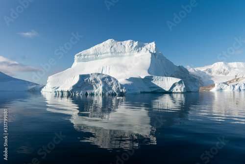 Ice berg reflected in calm water in the Errera Channel in Antarctica