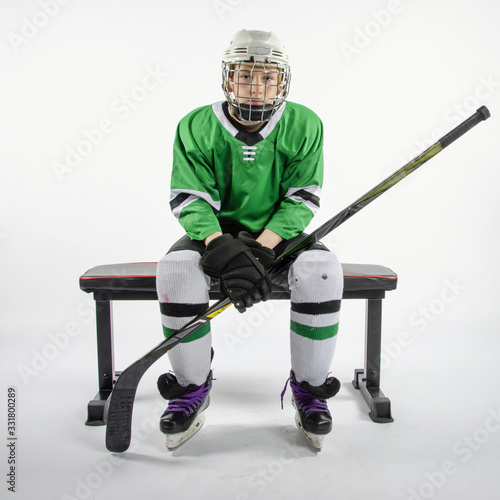 Photography Male youth hockey player sitting on bench waiting to play